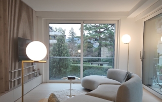 Un salon avec une grande fenêtre et un canapé blanc